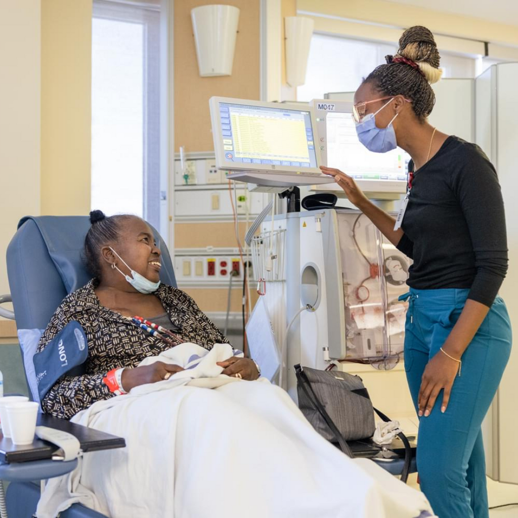 A healthcare worker chats with a patient receiving renal dialysis at the KW Campus.